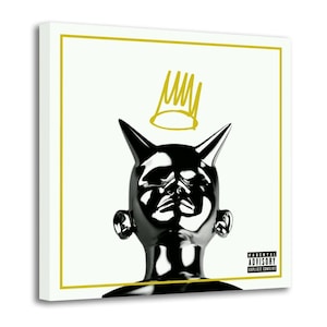 Könnte beinhalten: Quadratischer Leinwandkunstdruck mit einer schwarzen und silbernen Skulptur eines Kopfes mit spitzen Ohren und einer Krone darüber. Das Kunstwerk hat einen weißen Hintergrund mit einem goldenen Rand und den Worten "Parental Advisory Explicit Content".