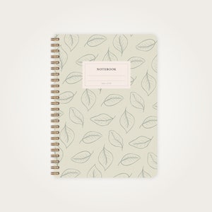 Könnte beinhalten: Ein hellgrünes Notizbuch mit Spiralbindung und einem Blatt-Muster. Der Einband hat ein Etikett mit der Aufschrift "NOTEBOOK".