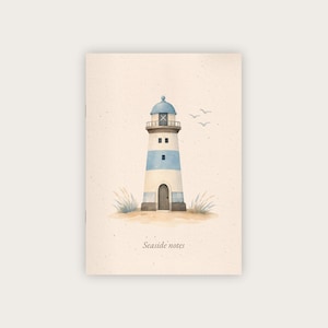 Könnte beinhalten: Ein Notizbuch mit einer Aquarellillustration eines Leuchtturms. Der Leuchtturm hat blau-weiße Streifen, eine blaue Spitze und eine kleine Tür. Die Worte "Seaside notes" sind unten auf dem Notizbuch aufgedruckt.