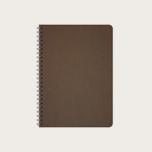 May include: A brown spiral bound notebook with a textured cover.