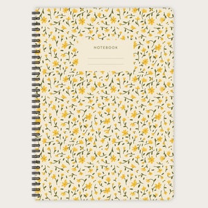 Könnte beinhalten: Ein cremefarbenes Notizbuch mit gelbem Blumenmuster und dem Wort "NOTEBOOK" auf dem Einband.