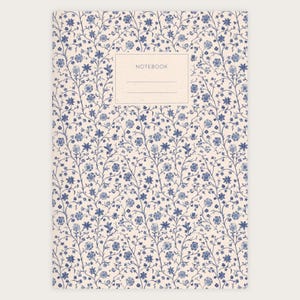 Könnte beinhalten: Ein Notizbuch mit einem blauen und weißen Blumenmuster auf dem Einband. Der Einband trägt den Aufdruck "Notebook" in einem braunen Rechteck.