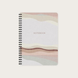 May include: A spiral bound notebook with a white cover and a colorful abstract design featuring wavy lines in shades of pink, brown, and beige. The word "NOTEBOOK" is printed in brown on the cover.