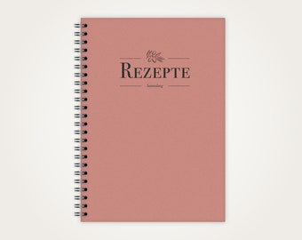 May include: A pink spiral bound notebook with the word "REZEPT" in black text on the front cover. The notebook is for writing down recipes.