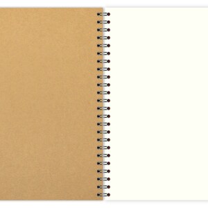May include: A brown cardboard notebook with a white spiral binding. The notebook is open to a blank white page.