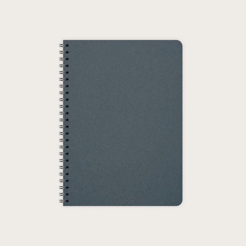May include: A dark blue spiral bound notebook with a textured cover.