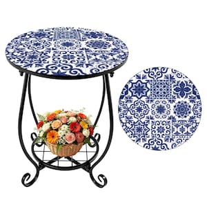 Może przedstawiać: Okrągły stolik boczny z blatem z niebiesko-białych płytek i czarną metalową ramą. Stół ma dolną półkę i kosz kwiatów. Stół ma średnicę około 61 cm.