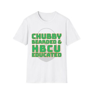 Puede incluir: Camiseta blanca con el texto "CHUBBY BEARDED & HBCU EDUCATED" en letras de bloque verdes y naranjas. El texto está centrado en la parte delantera de la camiseta, con una forma de corazón gris claro detrás.
