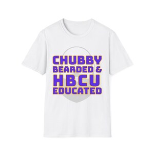 Puede incluir: Camiseta blanca con el texto "CHUBBY BEARDED & HBCU EDUCATED" en letras moradas y doradas. El texto está centrado en la parte delantera de la camiseta, con un círculo gris claro detrás.