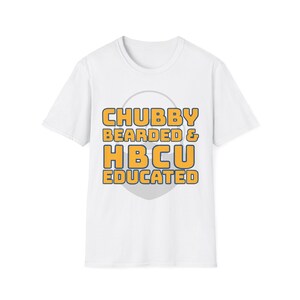 Puede incluir: Camiseta blanca con el texto "CHUBBY BEARDED & HBCU EDUCATED" en letras amarillas y naranjas. El texto está centrado en la camiseta, con un círculo gris detrás del texto.