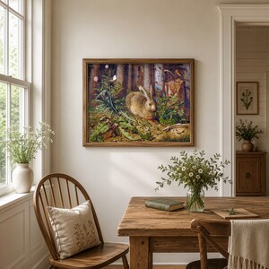 May include: A rectangular framed wall art print featuring a detailed illustration of a brown rabbit sitting in a lush forest setting with green foliage, tall trees, and small blue flowers, enclosed in a simple medium-toned wooden frame.