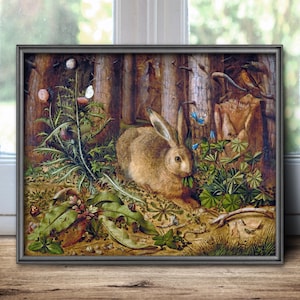 May include: A framed painting depicting a brown rabbit sitting in a forest clearing surrounded by green foliage, thistles, and small blue flowers. The scene includes a white butterfly, a small snail, and tree trunks in the background, all rendered in a detailed, naturalistic style with earthy tones.