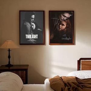 Puede incluir: Dos carteles enmarcados de la película "Twilight" cuelgan de una pared beige. Los carteles presentan imágenes de los personajes principales, con el título de la película. Los marcos son de color marrón oscuro.