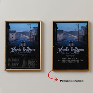 Puede incluir: Dos pósteres enmarcados que muestran una escena callejera oscura y melancólica al atardecer con un coche en la carretera. El texto dice Phoebe Bridgers The Lost Tour 2026, Alex G, y enumera fechas de gira o información de Indianapolis.