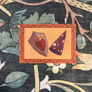 May include: A sticker featuring a shield with a heart and crown, and a purple wizard hat with pink stars. The sticker has an orange border with hearts and stars, set against a floral background.