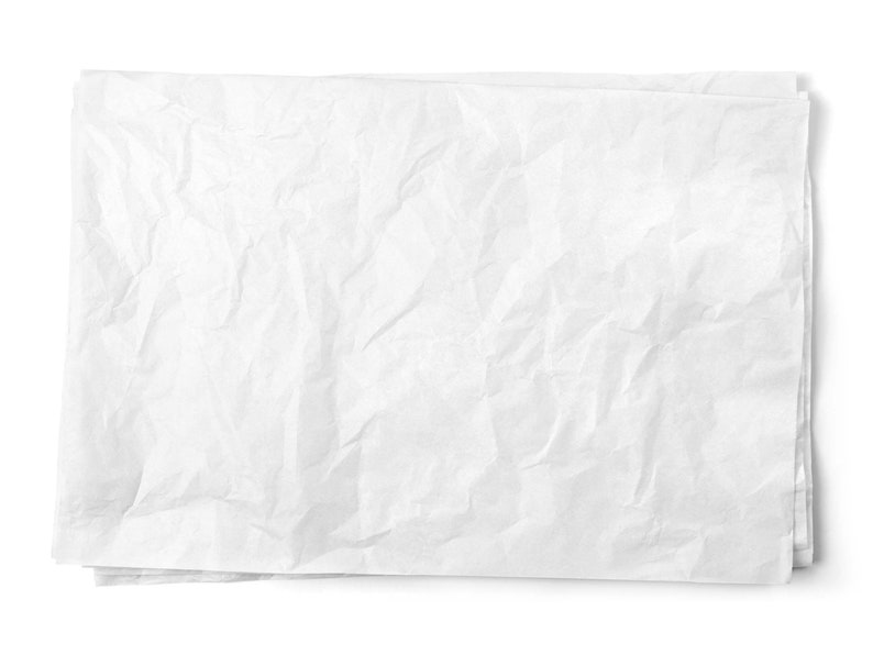 Pode incluir: Uma folha de papel branco amassada. O papel est&aacute; amassado e tem uma superf&iacute;cie texturizada.