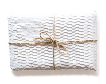 May include: A white gift box with a delicate, patterned design is wrapped with twine and tied with a bow.