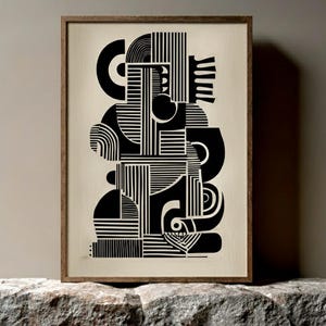 May include: Abstract black and white art print in a wooden frame. The artwork features geometric shapes, lines, and curves, creating a modern and minimalist design. The print is displayed on a stone surface.