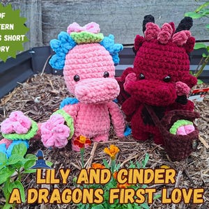 Puede incluir: Dos peluches de dragón tejidos a ganchillo, uno rosa con detalles azules y otro rojo oscuro, acompañados por una pequeña cesta tejida a ganchillo marrón. El texto en la imagen dice: PDF PATTERN & BONUS SHORT STORY, LILY AND CINDER A DRAGONS FIRST LOVE.