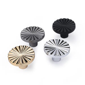 May include: A set of three ceramic mugs with a speckled, matte finish. Each mug features a different color: light blue, cream, and gray. The mugs have a simple, modern design and a comfortable handle.