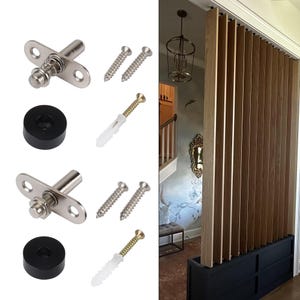 May include: A collection of hardware components, including silver-toned spring-loaded pins, screws, and black rubber bumpers. The image also shows a wooden slat room divider with a black base, providing a contrast to the light wood.