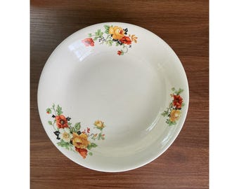 May include: A round, off-white ceramic bowl featuring a floral pattern with yellow and orange roses, red poppies, and green leaves. The botanical design is arranged in two clusters along the inner rim of the bowl, leaving the center plain.