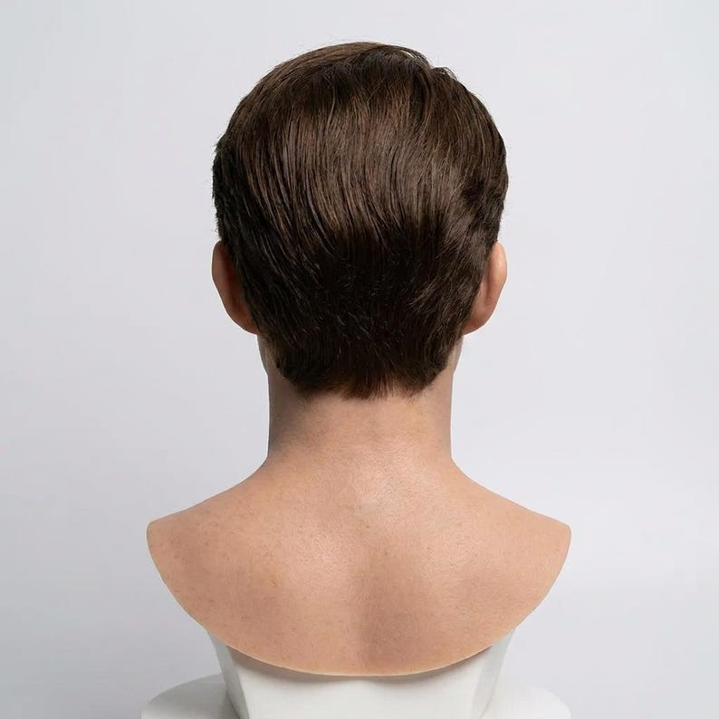 Pu&ograve; includere: Una parrucca corta di colore marrone con una consistenza naturale su una testa di manichino. I capelli sono tagliati vicino alla nuca, mostrando un aspetto a strati con ciocche visibili e una tonalit&agrave; marrone realistica su tutta la parrucca.