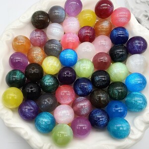 Könnte beinhalten: Ein Set aus drei Keramikbechern mit gesprenkelter, matter Oberfläche. Die Becher sind in Creme-, Hellgrau- und Dunkelgrautönen gehalten. Jeder Becher hat ein schlichtes, minimalistisches Design.