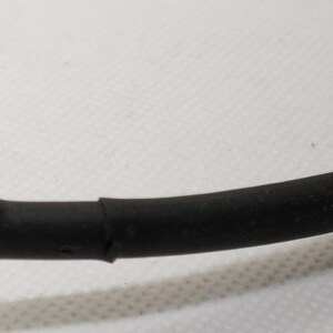 Puede incluir: Primer plano de un cable negro y marr&oacute;n. El cable est&aacute; curvado y parece estar hecho de goma o un material similar. La secci&oacute;n negra es m&aacute;s gruesa que la secci&oacute;n marr&oacute;n, y las dos secciones est&aacute;n unidas.