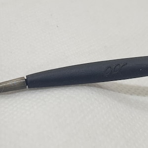 May include: Close-up of a black eyeglass arm with a silver-colored metal frame. The black portion has a subtle, curved design and the letters "00" are printed on the black portion.