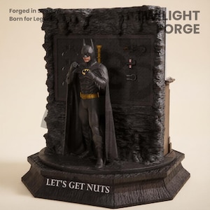 May include: A Batman figurine stands on a base with the text "LET'S GET NUTS". The figure is in a black suit with a yellow belt and bat symbol. The background features a textured wall with the words "THE LIGHT FORGE".