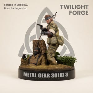以下が含まれることがあります： Twilight Forgeの精巧なフィギュア。軍服姿の2体の人物が描かれています。一人はピストルを構え、もう一人は部分的に水没しています。「METAL GEAR SOLID 3 SNAKE EATER」と書かれた台座。背景には「Forged in Shadow. Born for Legends.」の文字。