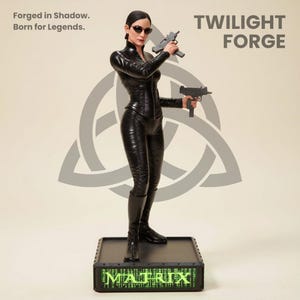 Puede incluir: Estatua negra de una mujer con un atuendo negro sosteniendo dos pistolas. La estatua está sobre una base negra con la palabra "MATRIX" en verde. El texto "Forged in Shadow. Born for Legends." está en la esquina superior izquierda. El texto "TWILIGHT FORGE" está en la esquina superior derecha.