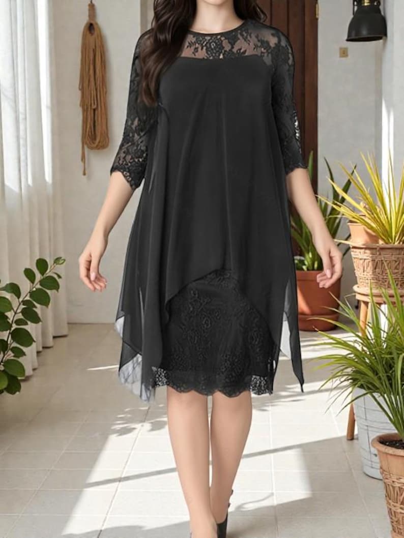 Puede incluir: Vestido negro con dise&ntilde;o en capas. El vestido presenta un corpi&ntilde;o y mangas de encaje, con una superposici&oacute;n fluida y transparente. El dobladillo llega justo por debajo de la rodilla. Adecuado para ocasiones formales.
