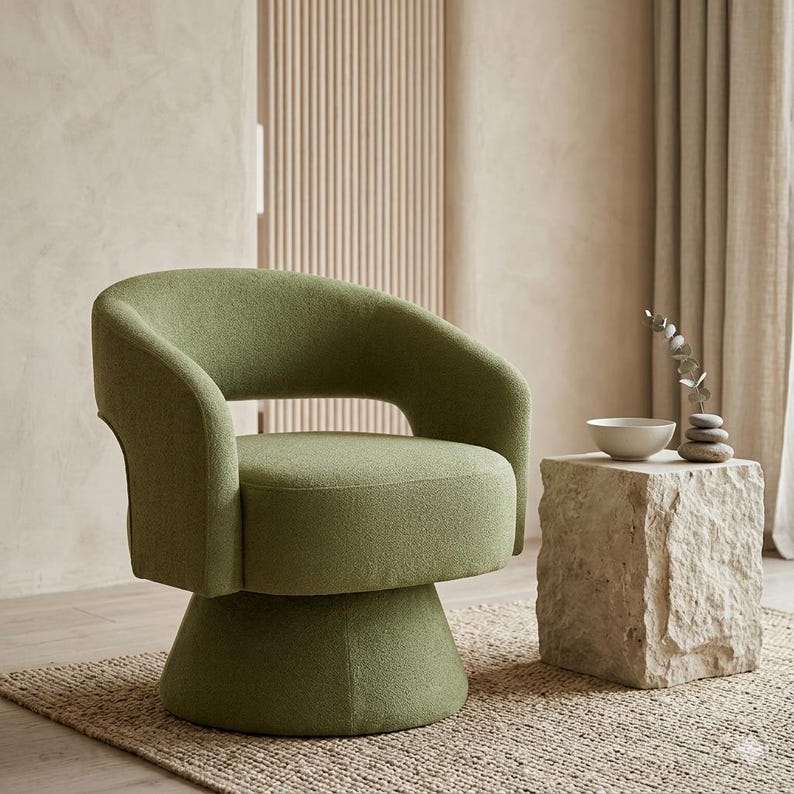 May include: A green swivel chair with a rounded back and armrests. The chair sits on a pedestal base. Beside the chair is a stone side table with a small white bowl and decorative stones.