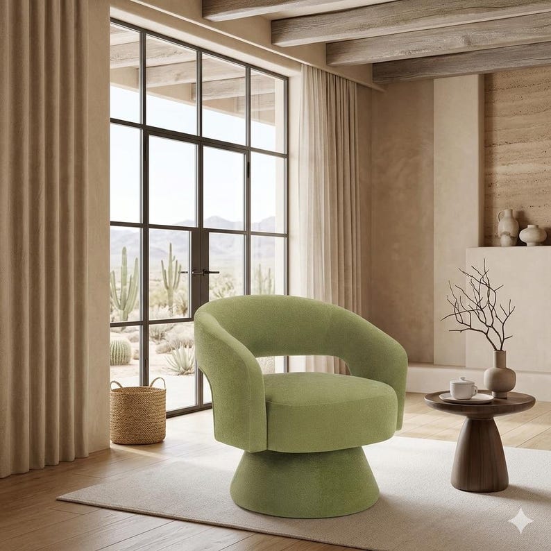 May include: A modern, swivel accent chair in a soft, light green fabric. The chair has a rounded back and armrests, and sits on a pedestal base. The chair is in a room with a large window, curtains, and a small side table.