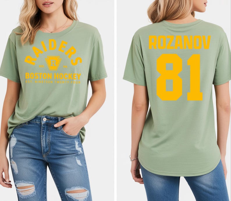 May include: Sage green t-shirt with the word "RAIDERS" arched across the chest in yellow, along with a logo and "BOSTON HOCKEY" text. The back of the shirt displays "ROZANOV" and the number "81" in yellow.