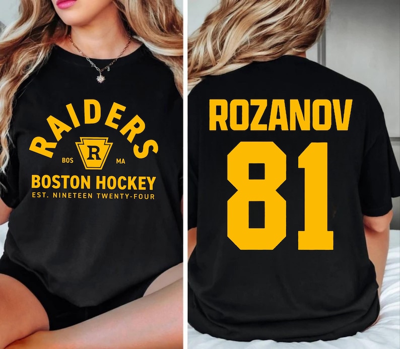May include: Black t-shirt with "RAIDERS" arched text in yellow, above a yellow and black crest with "R" inside. Below, "BOSTON HOCKEY" and "EST. NINETEEN TWENTY-FOUR" in yellow. The back features "ROZANOV" and the number "81" in yellow.
