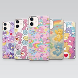 May include: Five phone cases with Care Bear designs in various colours. Each case displays a different pattern, including bears, rainbows, hearts, and planets. The cases are made of clear plastic and are designed to fit a smartphone.