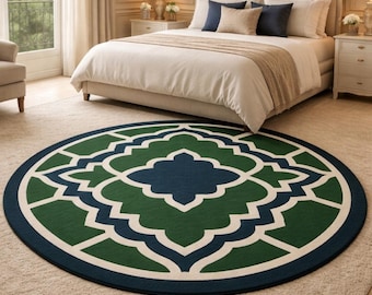 May include: A round area rug with a geometric pattern in shades of green, navy blue, and white. The rug is placed on a neutral-colored carpet in a bedroom setting. The rug's diameter is approximately 6 feet.