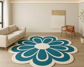 May include: A large, flower-shaped area rug with a teal blue and off-white design. The rug is the focal point of a living room, with a cream-colored sofa, wooden chair, and neutral walls. The rug's dimensions are approximately 7 feet in diameter.
