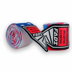 May include: A white ceramic mug with a black handle and the text "But First, Coffee" in a bold, black font. The mug is set against a blurred background, suggesting a cozy setting.