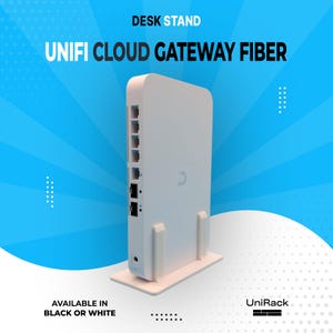 May include: A white Unifi Cloud Gateway Fiber desk stand. The device has multiple ports and is mounted on a white base. The text "DESK STAND" and "UNIFI CLOUD GATEWAY FIBER" are displayed at the top. The text "AVAILABLE IN BLACK OR WHITE" is at the bottom.