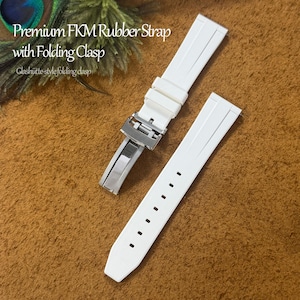 Peut inclure: Bracelet de montre en caoutchouc FKM blanc avec fermoir déployant. Le bracelet est présenté en deux parties, avec un fermoir en acier inoxydable. Le texte "Premium FKM Rubber Strap with Folding Clasp" est visible.