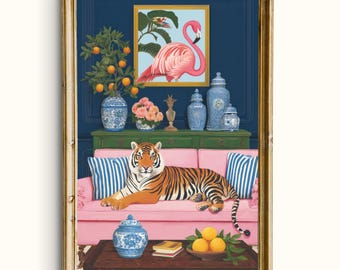 May include: A framed art print featuring a tiger lounging on a pink sofa. The artwork includes a flamingo painting, blue and white vases, and a table with oranges. The background is a dark blue wall with a gold frame.