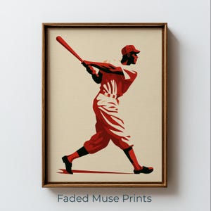 Puede incluir: Una impresión artística enmarcada que presenta una ilustración gráfica estilizada de un jugador de béisbol con uniforme rojo y negro balanceando un bate. El jugador está representado de perfil sobre un fondo crema. El texto Faded Muse Prints es visible.