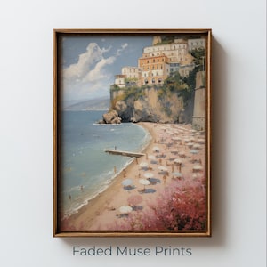 May include: A framed art print showing a coastal scene with a beach, buildings on a cliff, and a blue sea. The artwork uses a warm colour palette with pink, beige, and blue hues. The text "Faded Muse Prints" is at the bottom.