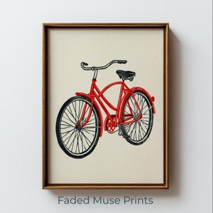 May include: A framed art print featuring a red bicycle illustration with black wheels and handlebars on a cream background. The text Faded Muse Prints is printed in blue at the bottom of the frame. The frame is made of brown wood.
