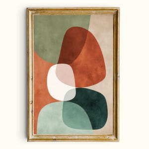 May include: Abstract art print in a gold frame. The artwork features overlapping organic shapes in shades of green, rust, white, pink, and teal against a beige background. The framed art piece is a modern wall decor item.