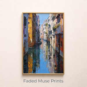 Peut inclure: Peinture à l'huile encadrée d'une scène de canal vénitien. L'œuvre représente des bâtiments colorés bordant l'eau, avec des reflets dans l'eau bleue. La peinture a un cadre doré et le texte "Faded Muse Prints" en bas.